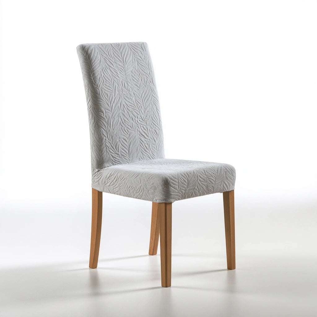 Housse extensible pour siège en tissu gris clair sur une chaise de salle à manger, protection élégante et ajustée.